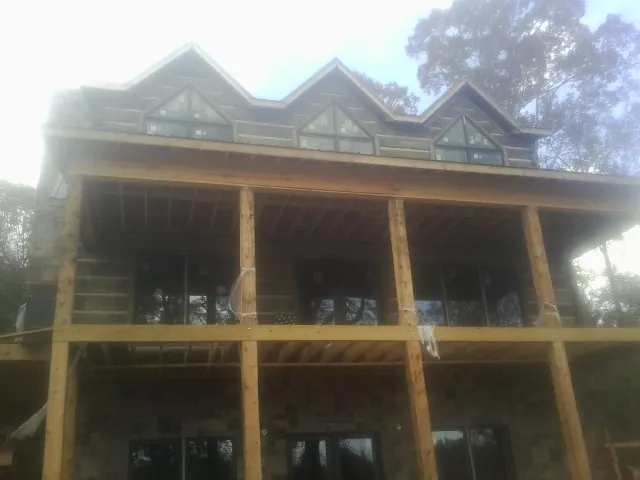 Dormers and porch framing on a large log home under construction — Roof Coating work by our crew in Hockessin